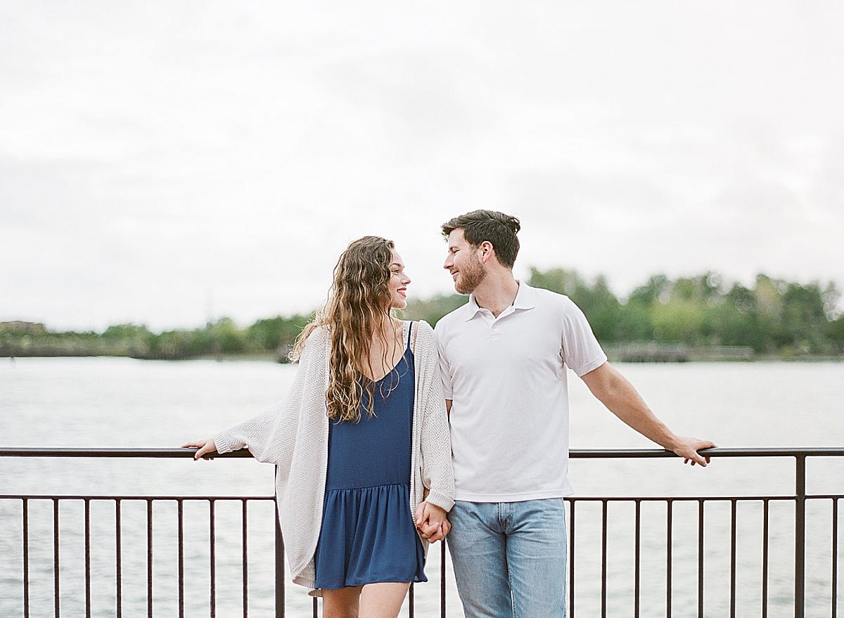 Couple Looking at Each Other Leaning on Railing Photo