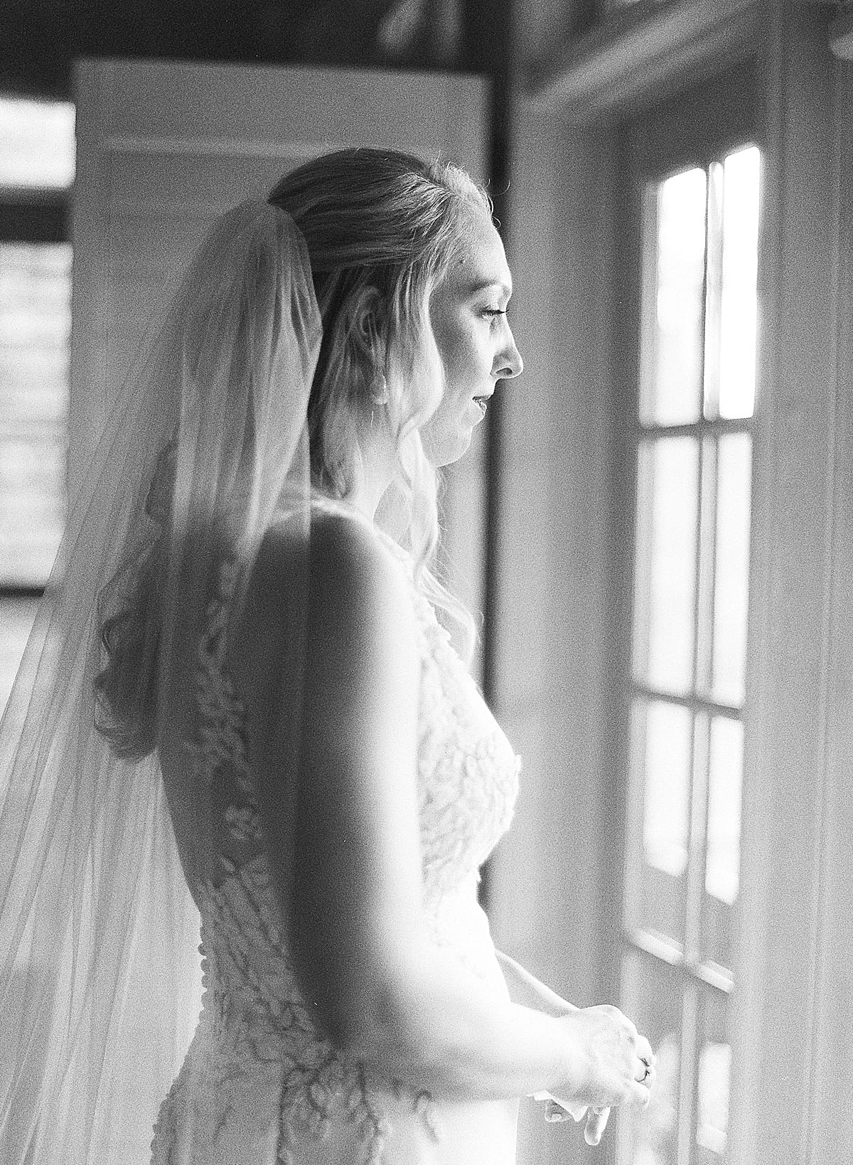 Black and White of Bride Looking Out Window Photo