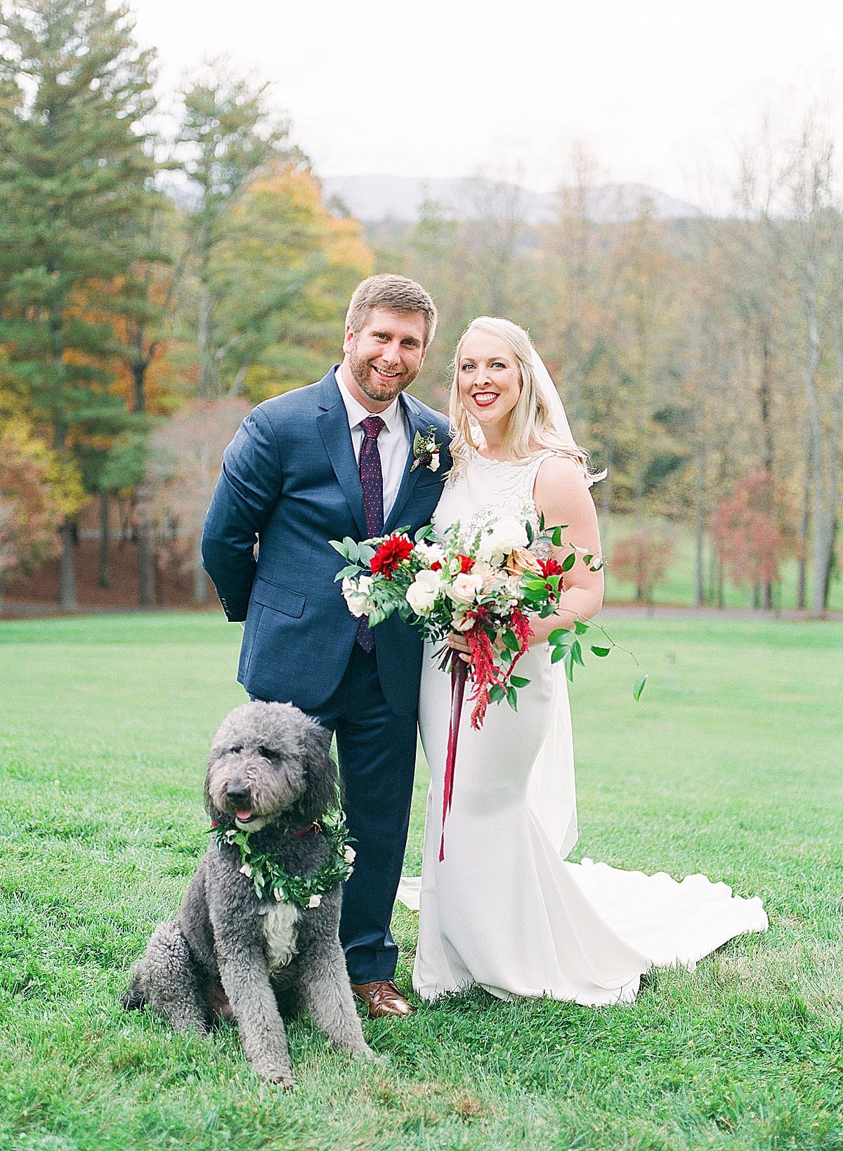 Bride and Groom Smiling at Camera with Dog Photo