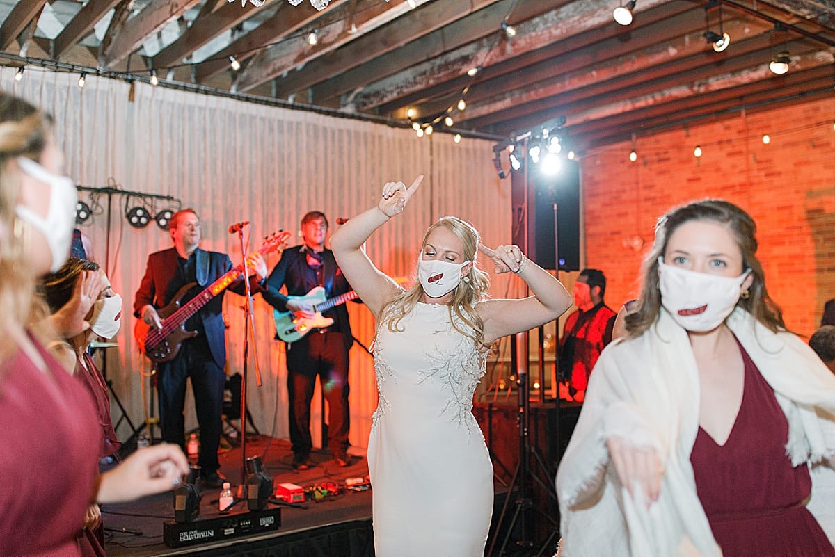 Bride with Face Mask Dancing with Friends at Her Reception Photo