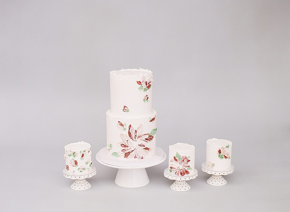 Small Cake with Three Smaller Cakes on Pedestals With Painted Icing Flowers Photo