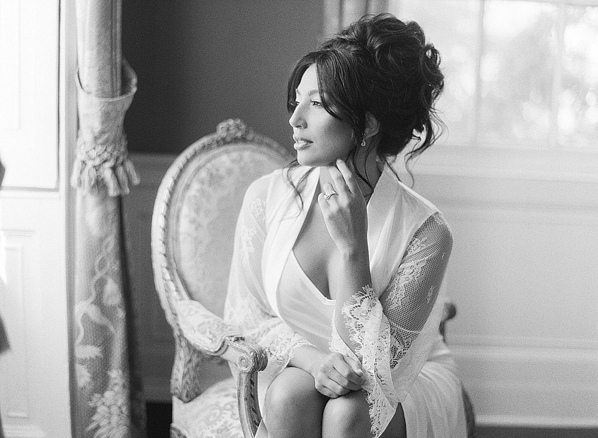 Black and White of Bride in Robe Looking out Window Photo