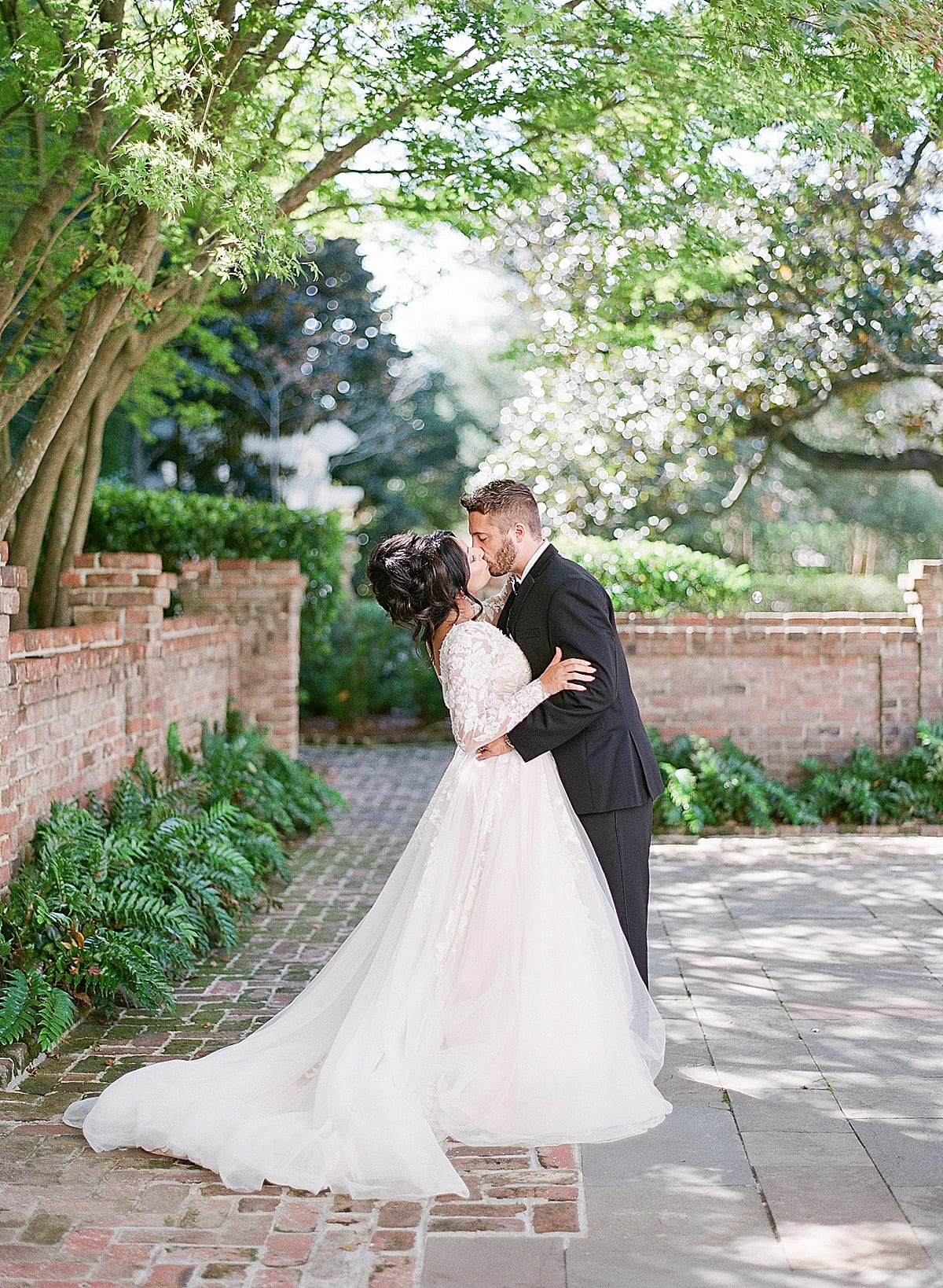 Bride and Groom Kissing in William Aiken House Garden Photo
