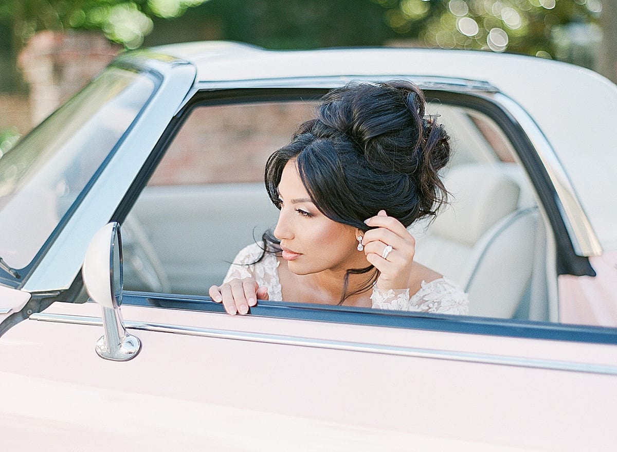 Bride Looking in Mirror of Vintage Pink Car Photo