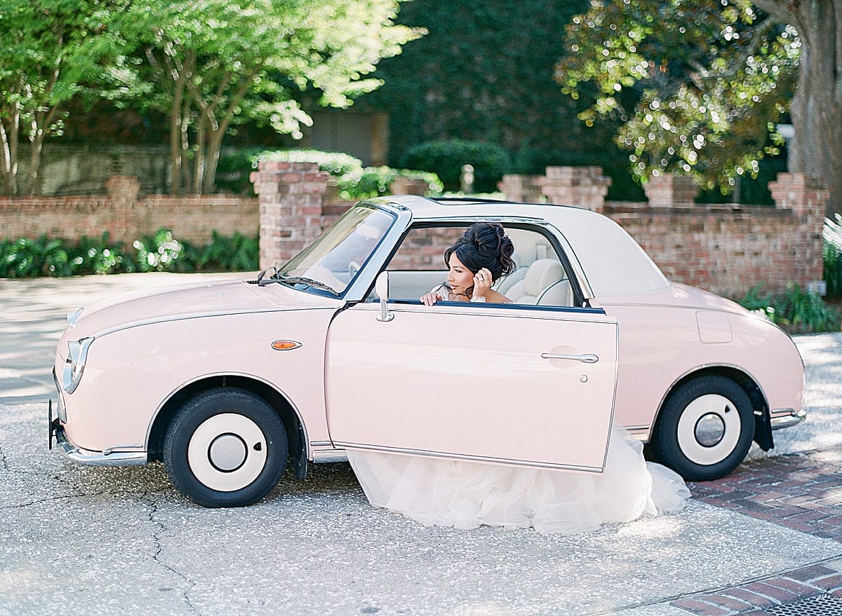 Bride Looking in Mirror Sitting in Vintage Pink Car in Charleston Photo