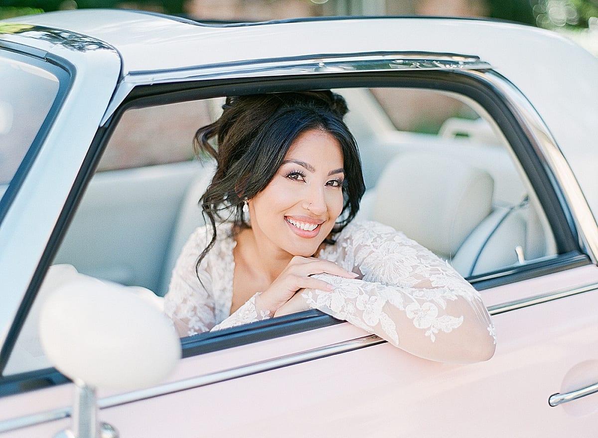 Bride Smiling at Camera in Pink Car Photo