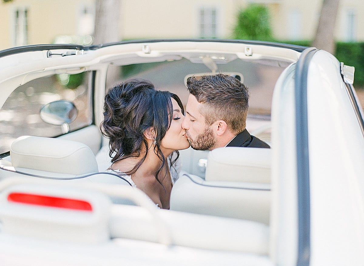 Bride and Groom Kissing in Vintage Car Photo