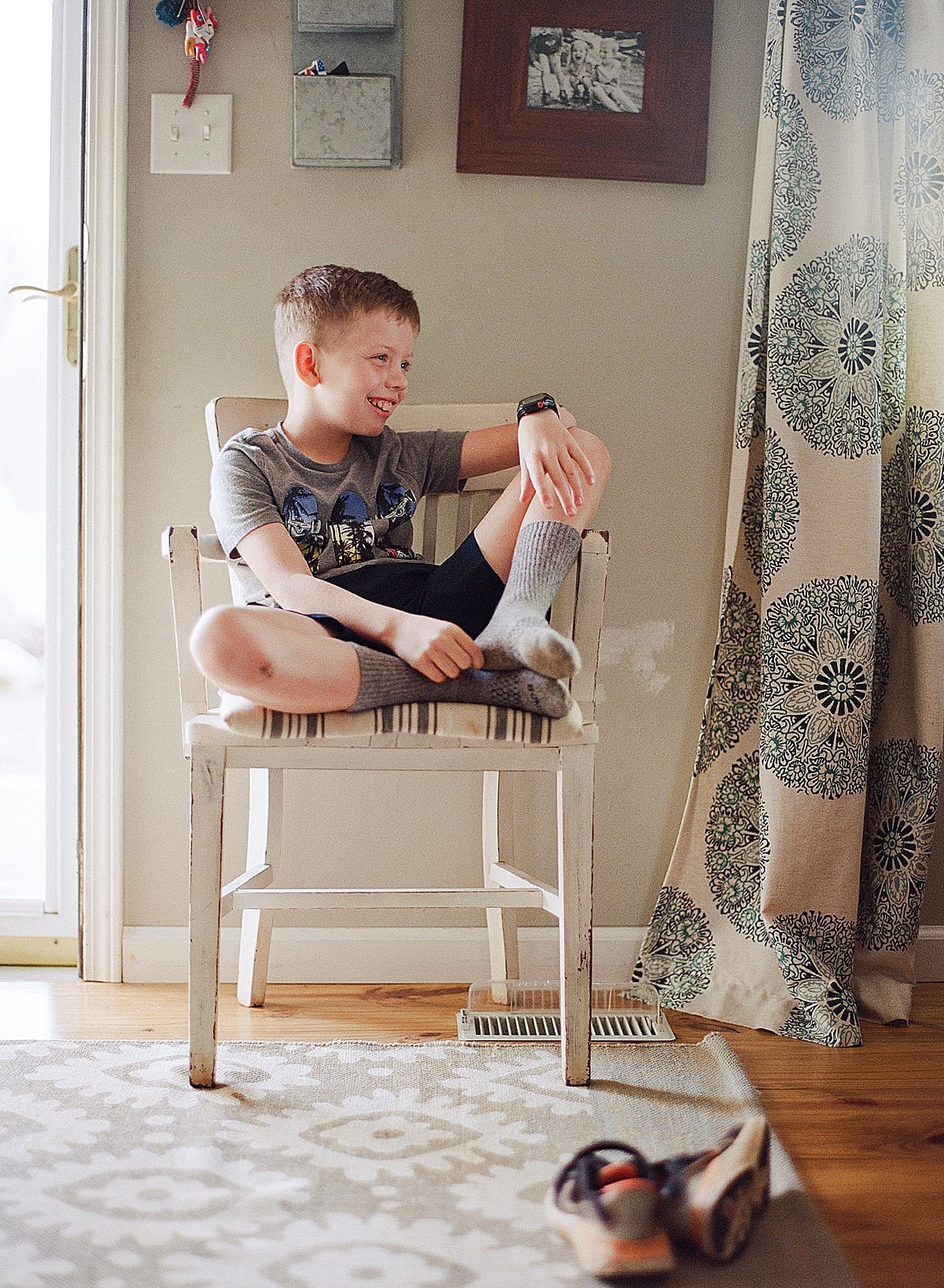 Boy sitting in Chair looking off smiling photo 