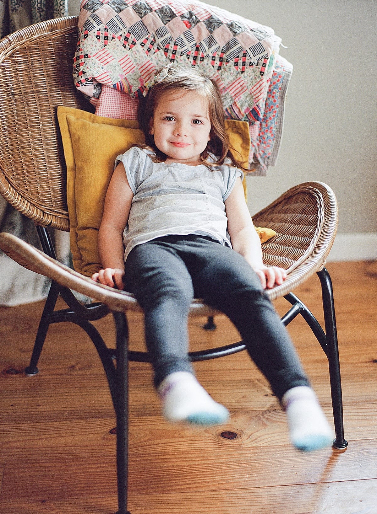little girl sitting in chair smiling at camera photo