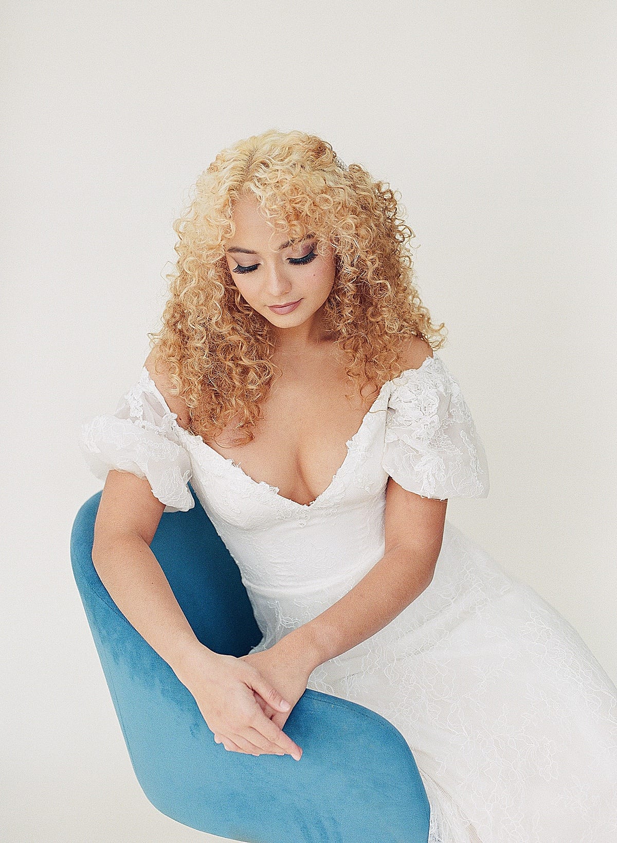 Bride sitting in Blue Chair looking down Photo