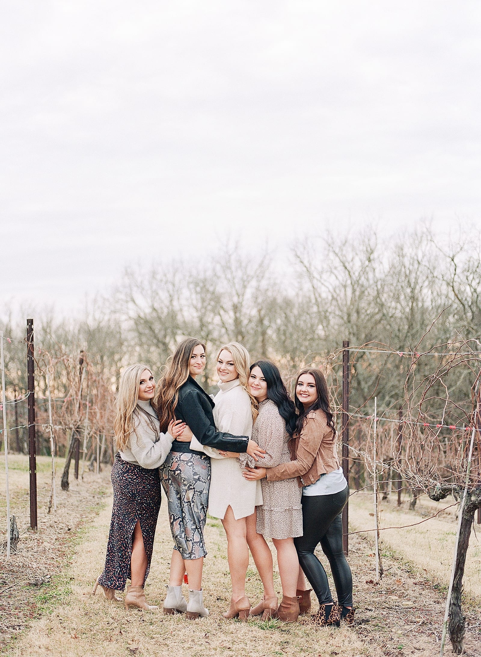 Bachelorette Weekend Itinerary Bride hugging bridesmaids at vineyard photo