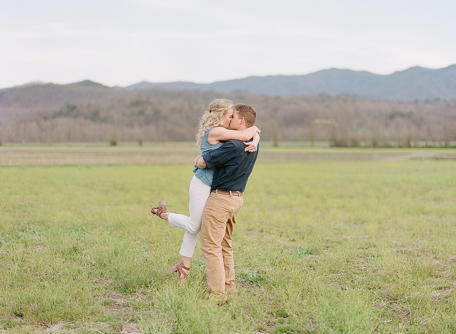 Couple kissing and spinning in North Carolina Mountains field Photo