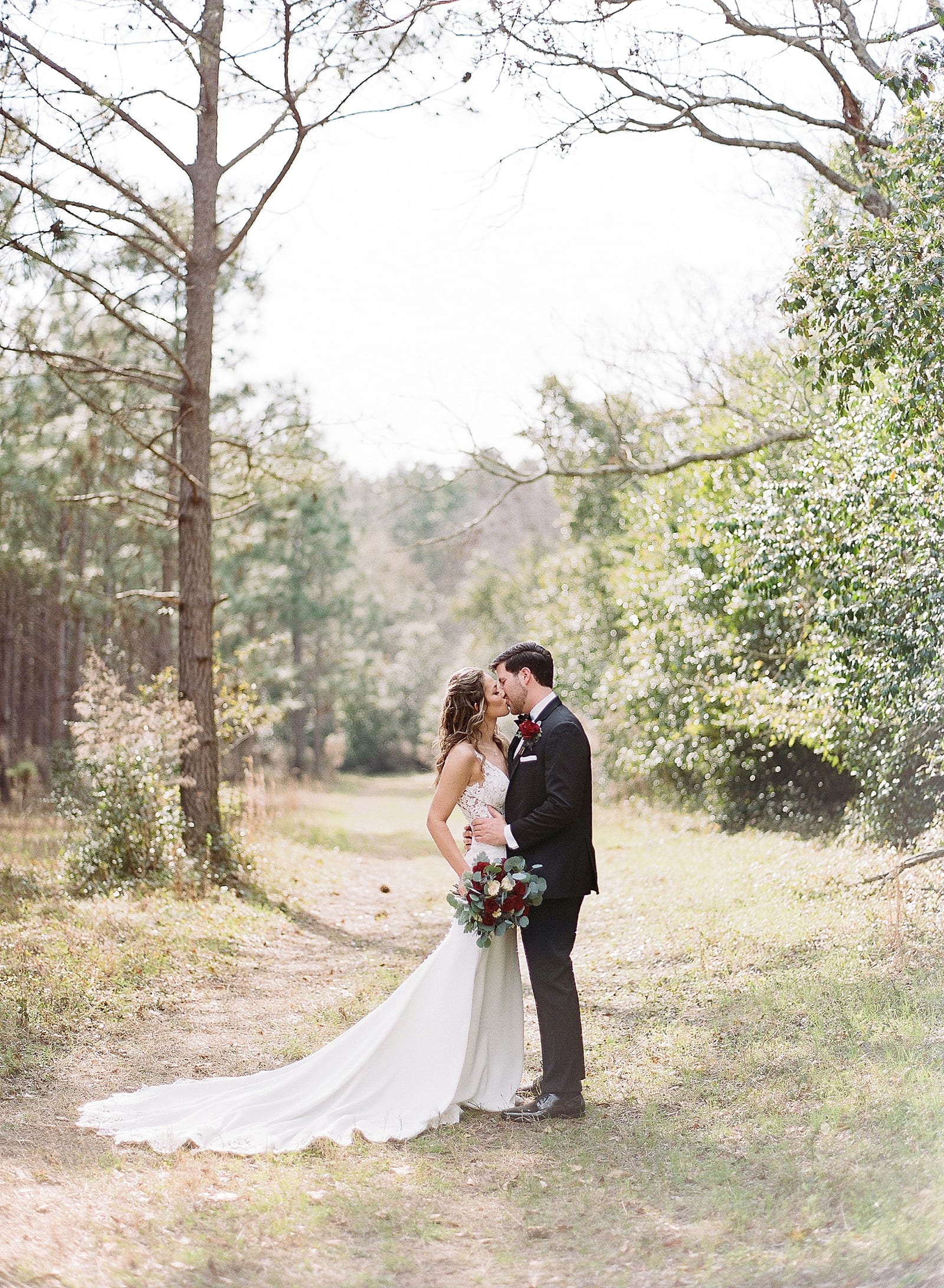 Bride and Groom Kissing in Woods Photo