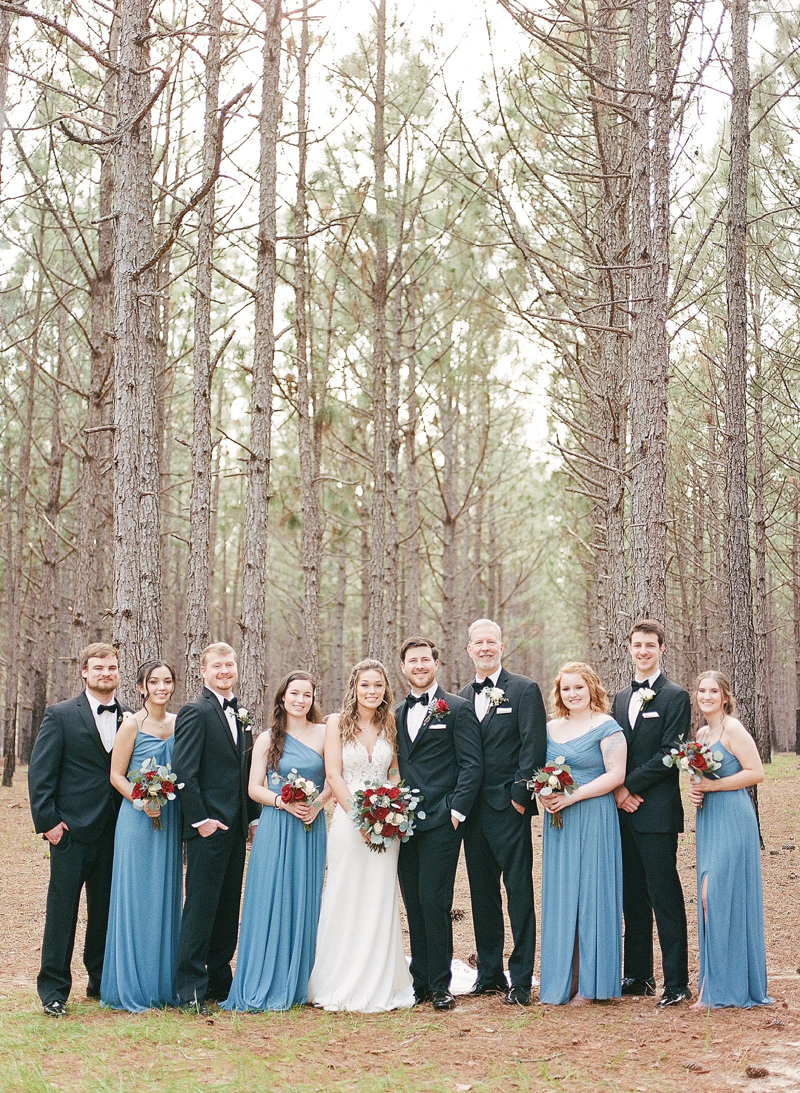 Bride and Groom with Bridal Party in Pine Trees Photo