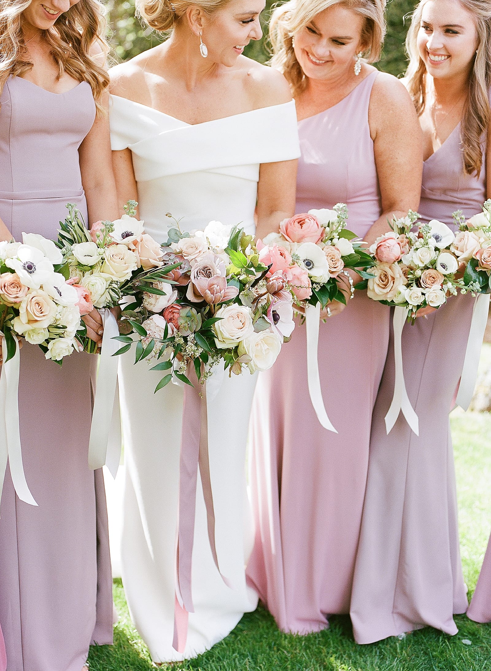 Bride with Bridesmaids in Purple Gowns Holding Bouquets Photo