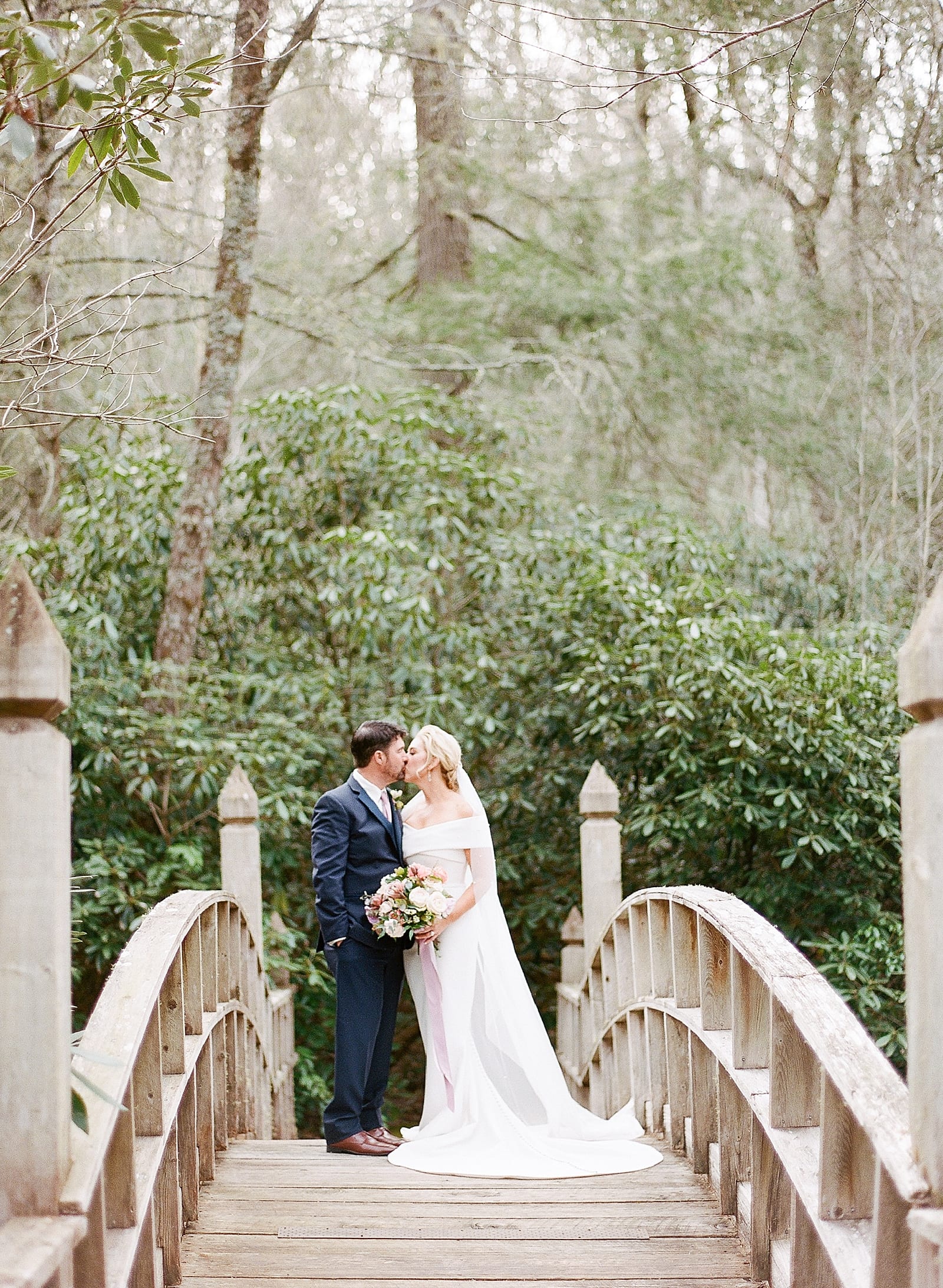 Old Edwards Inn Wedding Bride and Groom Kissing on Bridge Photo