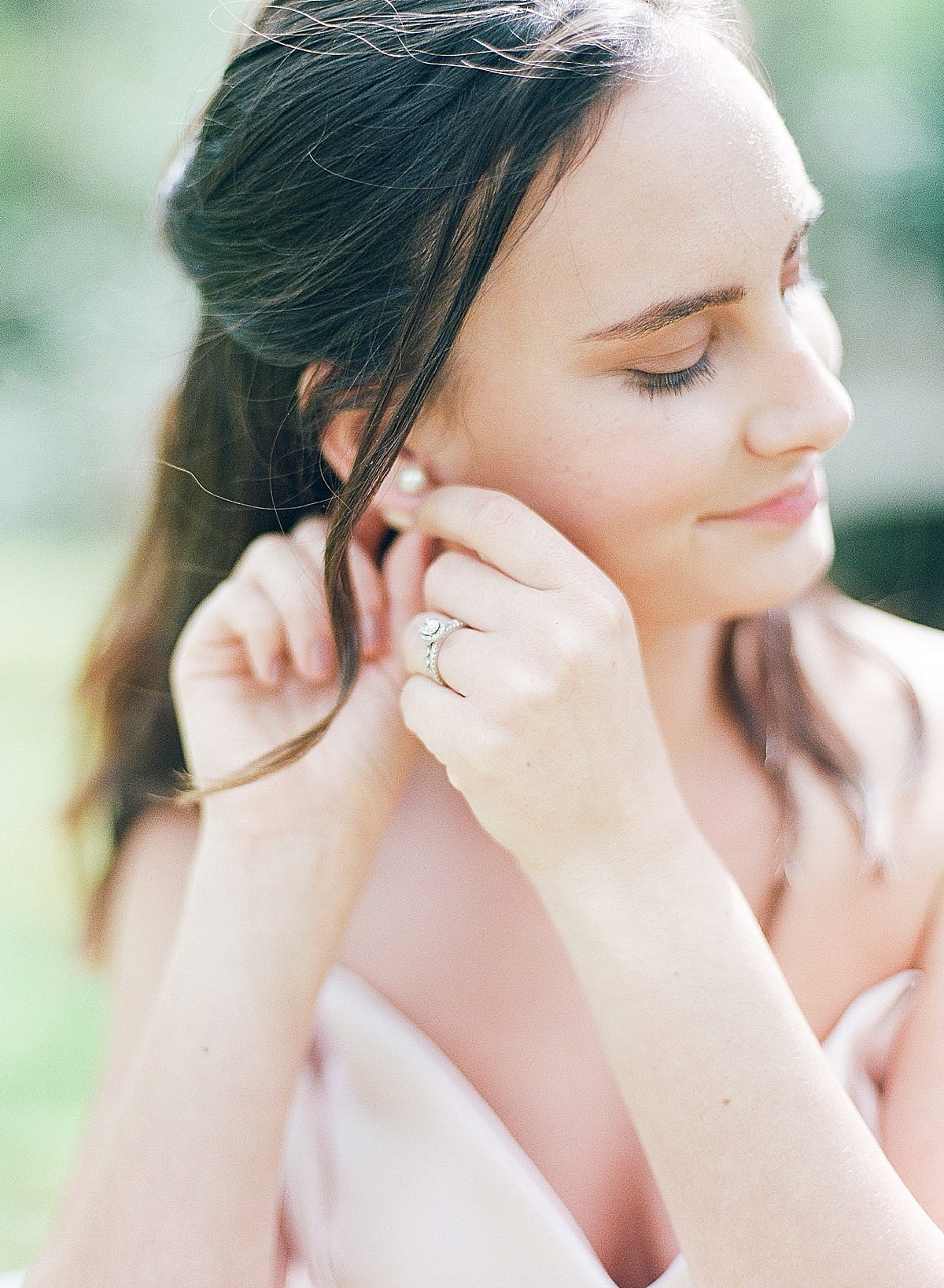 Bride putting on earrings Photo