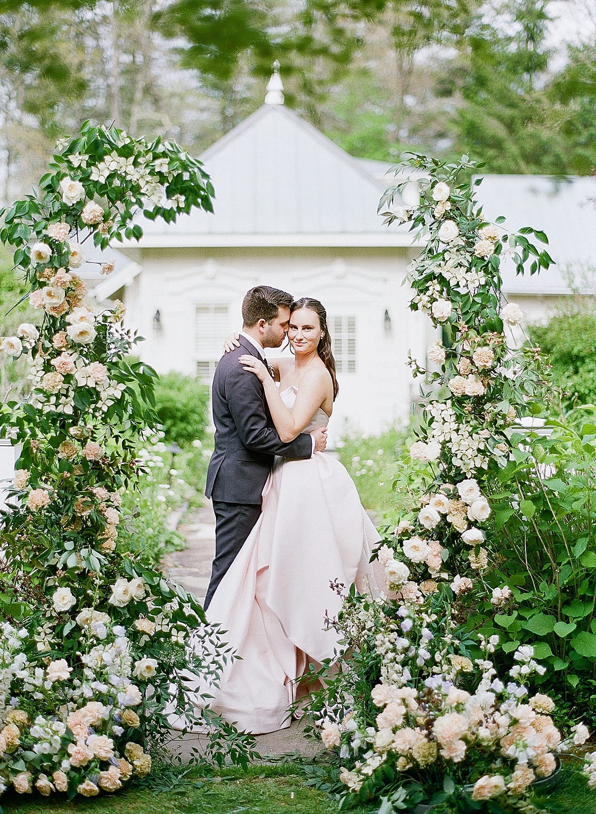Bride and Groom surrounded by floral arch photo