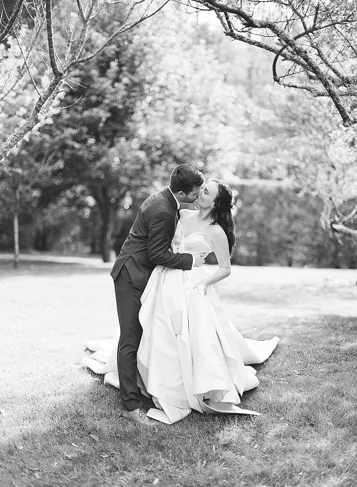 Old Edwards Inn Wedding Inspiration Black and White of Bride and Groom Kissing in Orchard Photo
