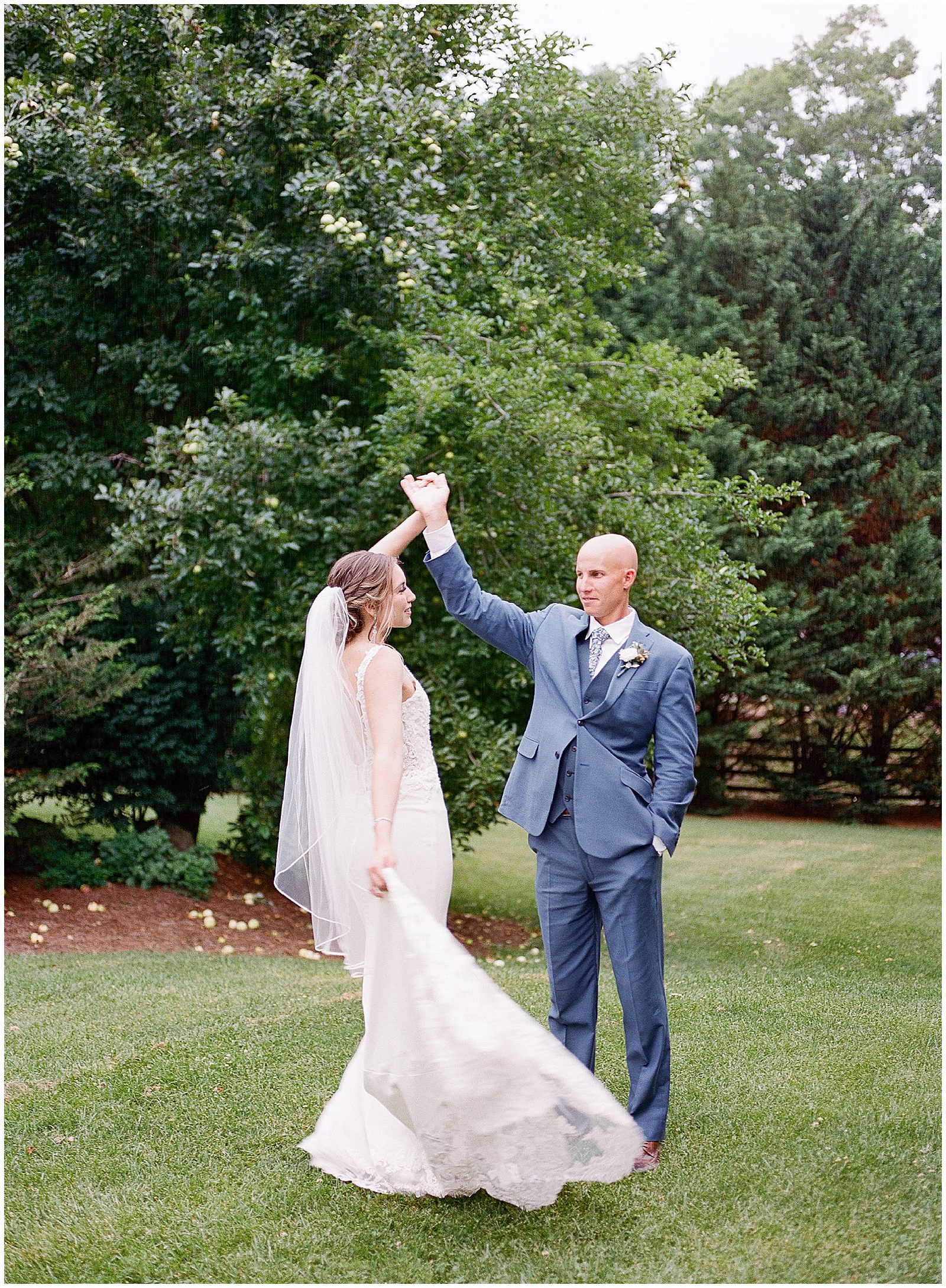 Groom Twirling Bride In Field Photo