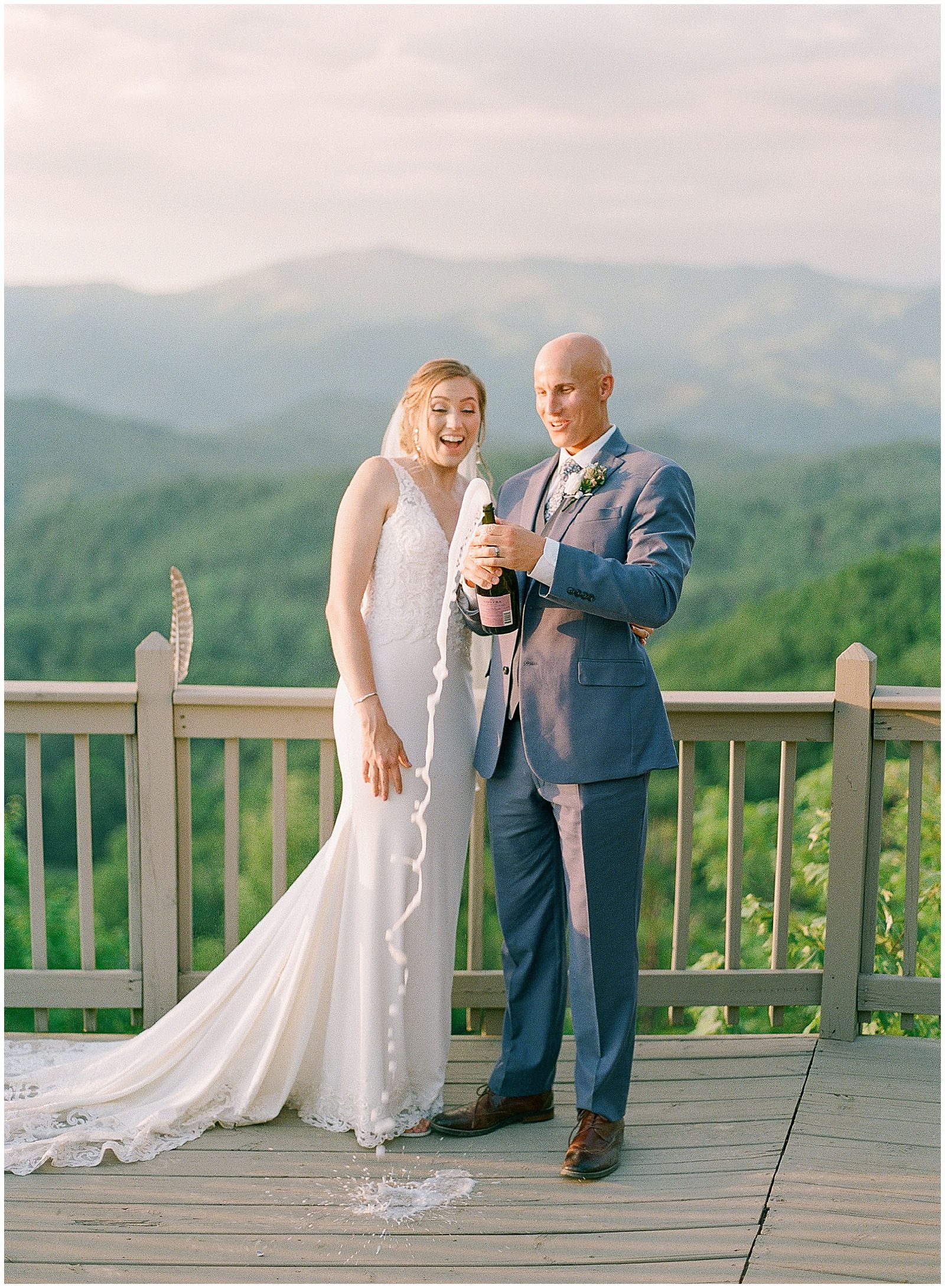 Couple Popping Champagne With Mountain View Photo