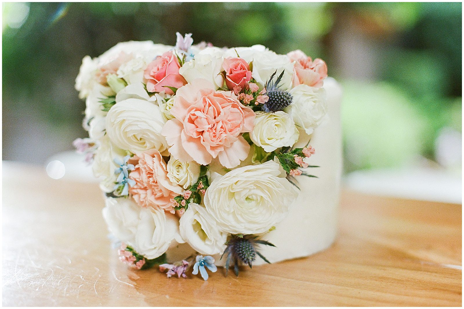 Small wedding Cake Covered in Flowers Photo