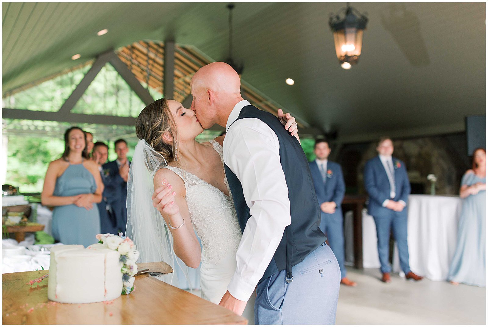 Bride and Groom Kissing After Cutting Cake Photo