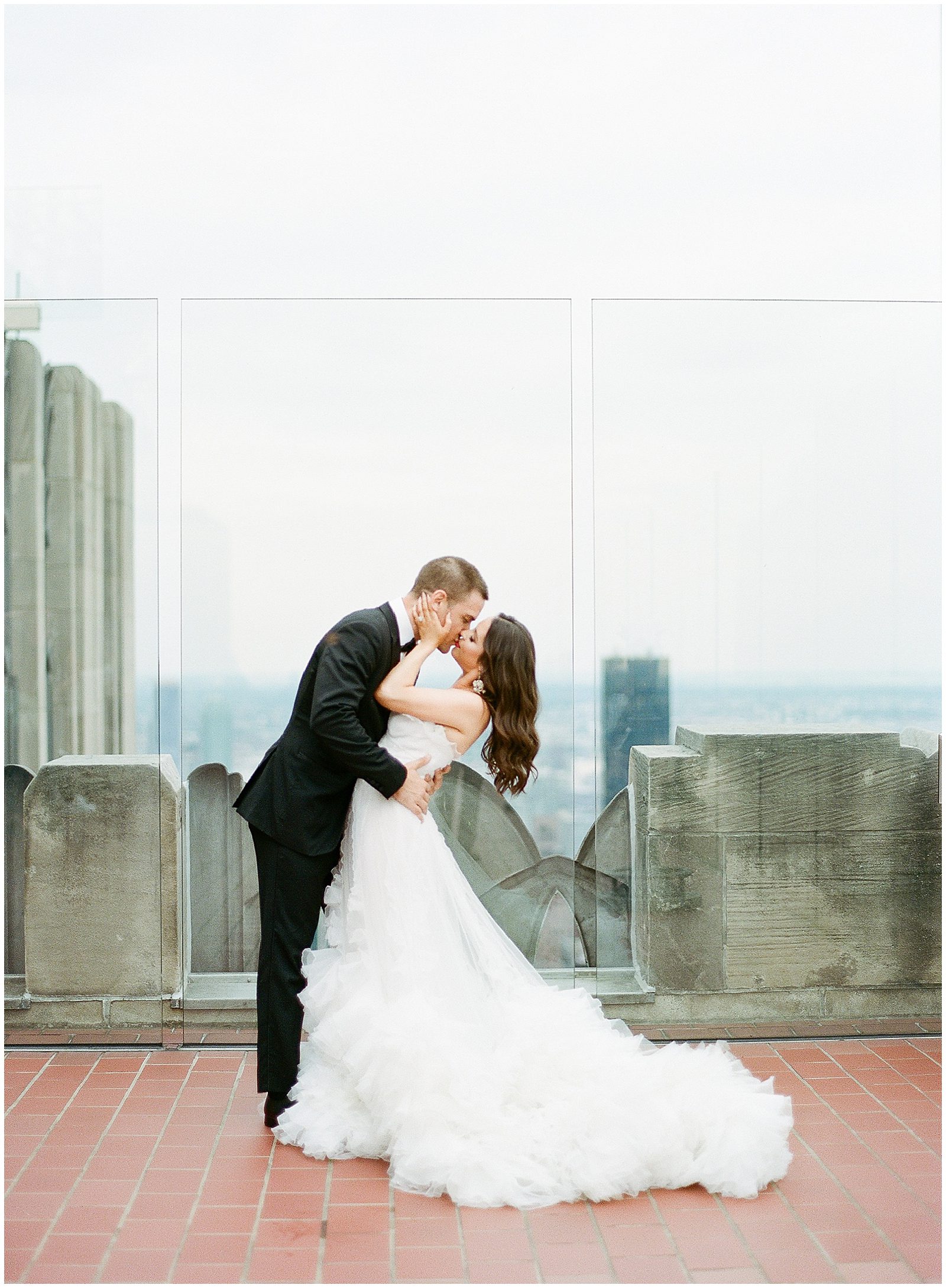 Bride and Groom Kissing at the Top Of The Rock in NYC photo