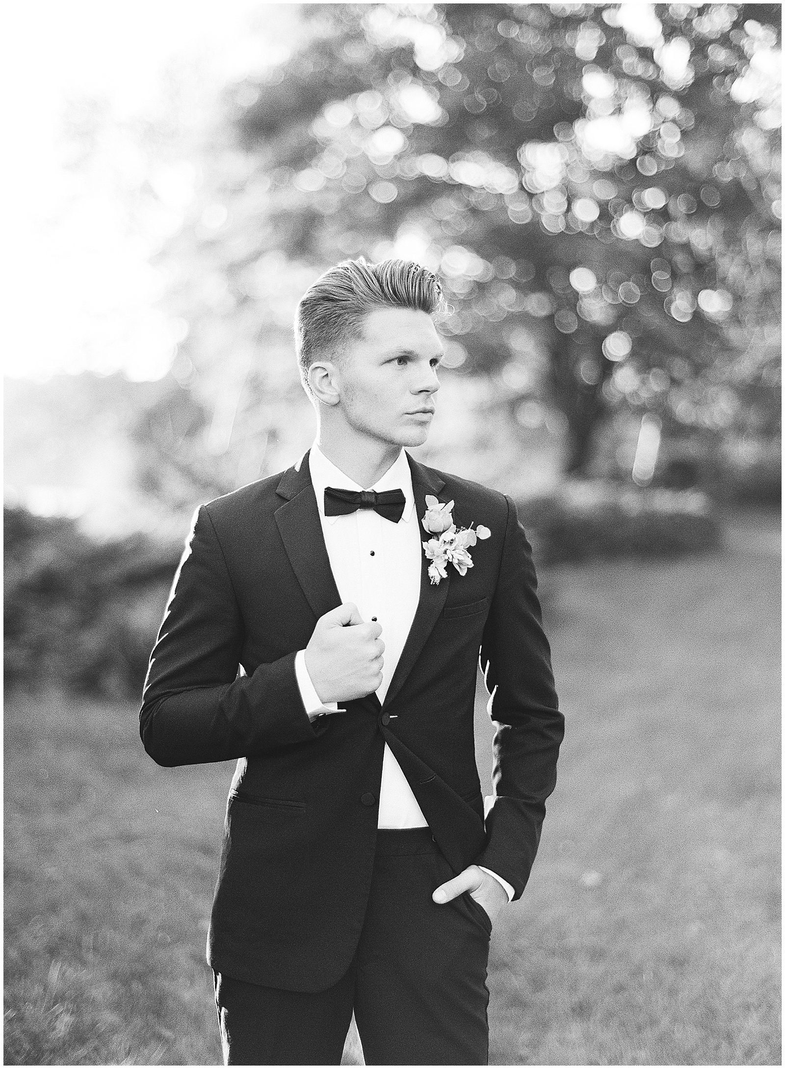 Tennessee Wedding Photographer Captures Black and White of Groom Looking Off Holding Lapel Photo