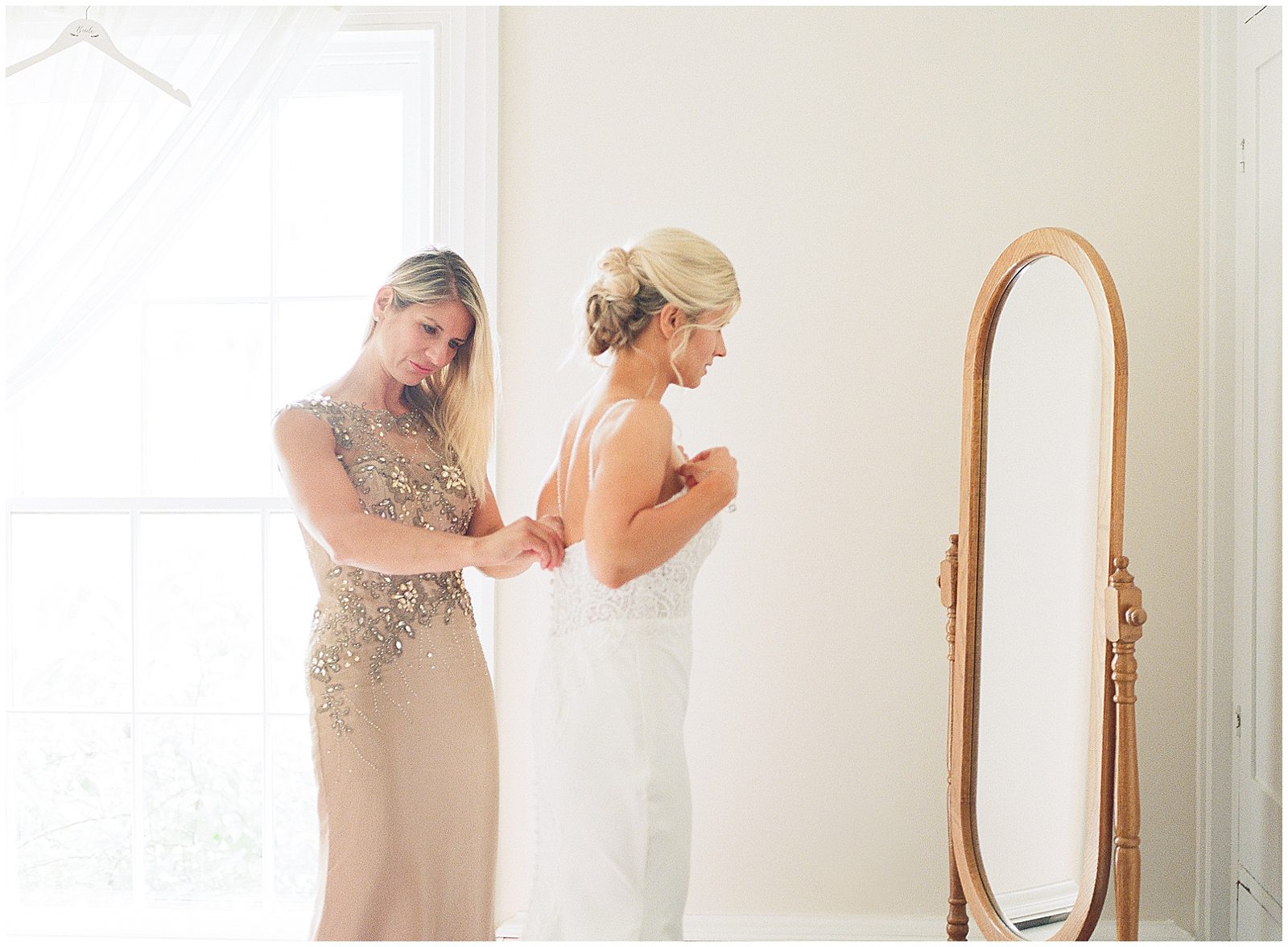 Mother of Bride Helping Bride with Dress Photo