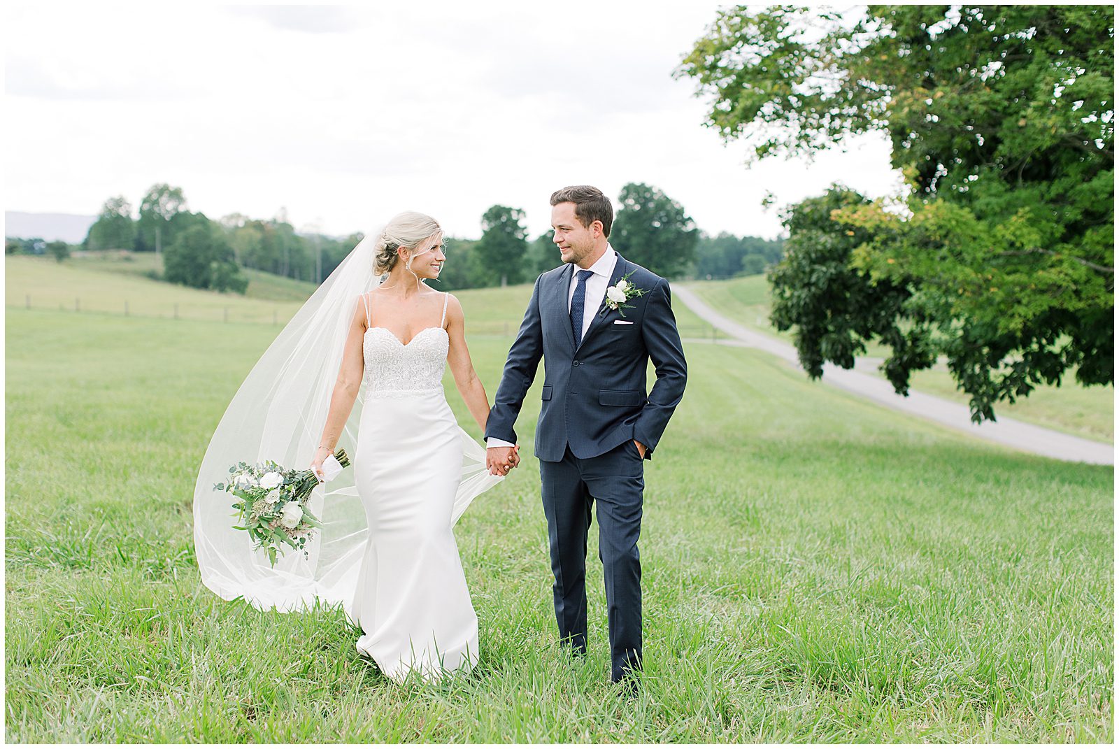 Bride and Groom Walking Through a Field Photo