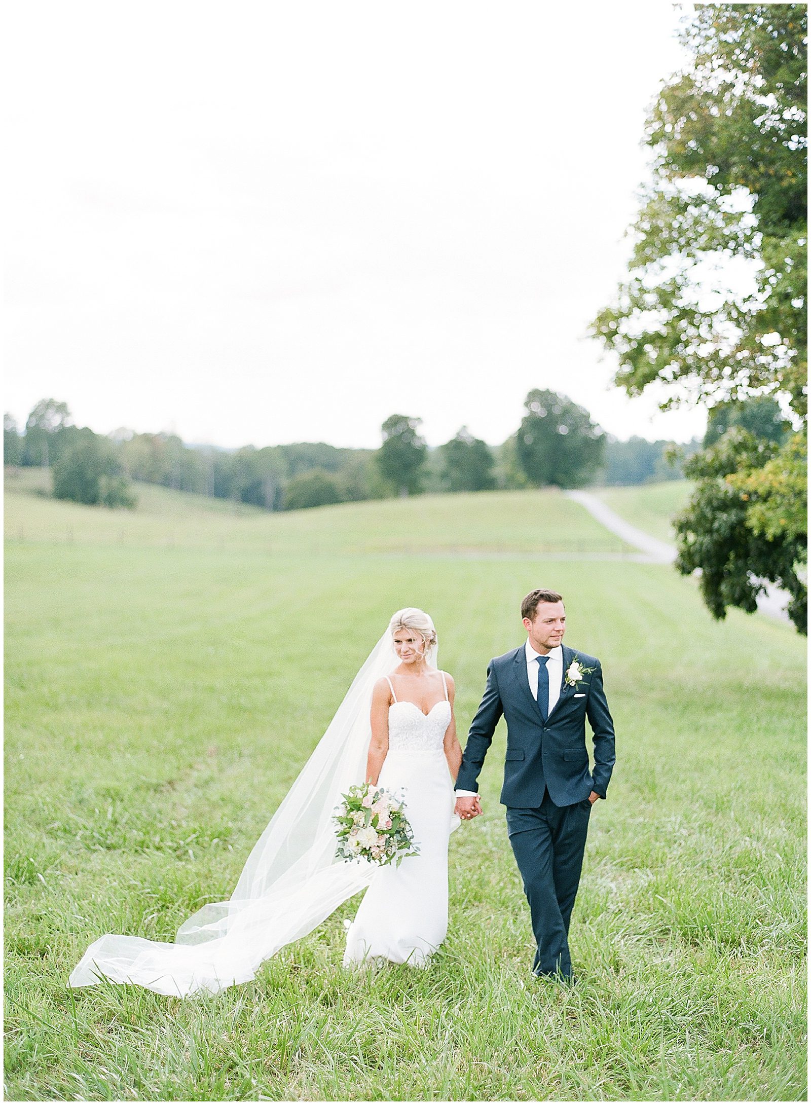 Bride and Groom Holding Hands in Field Photo