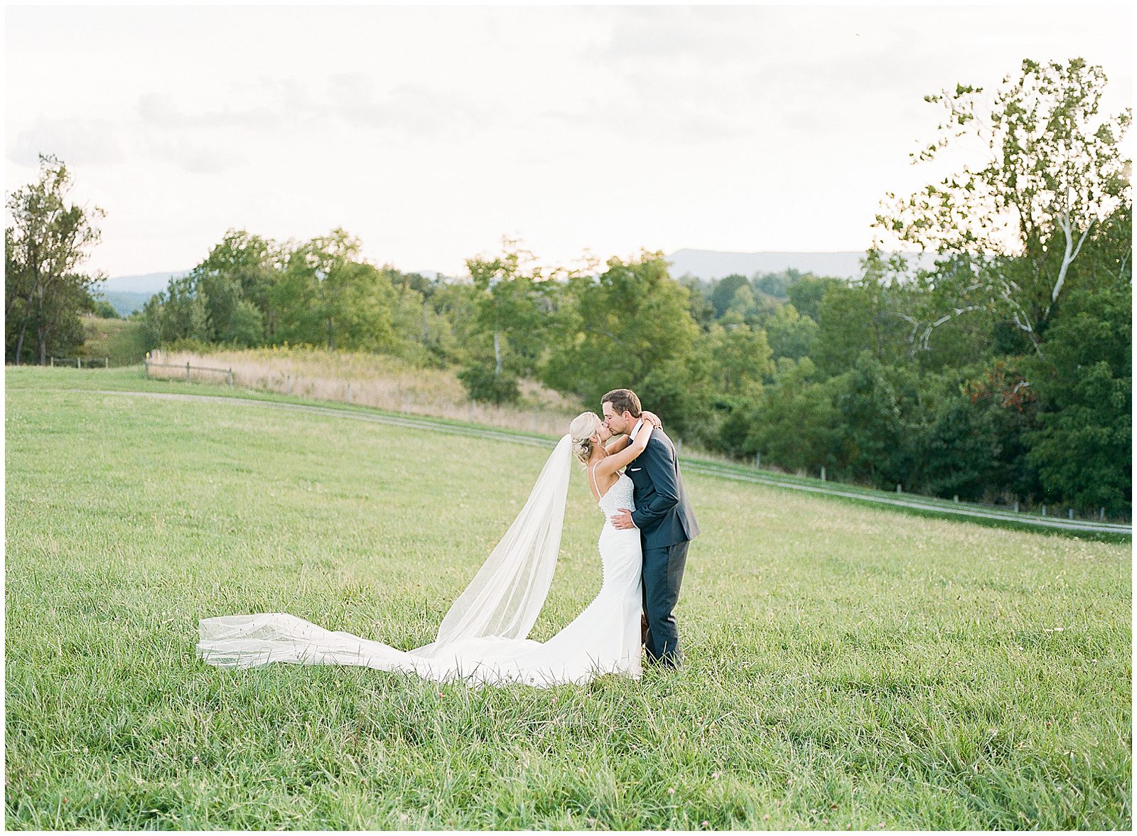 Bride and Groom Kissing In Field Photo