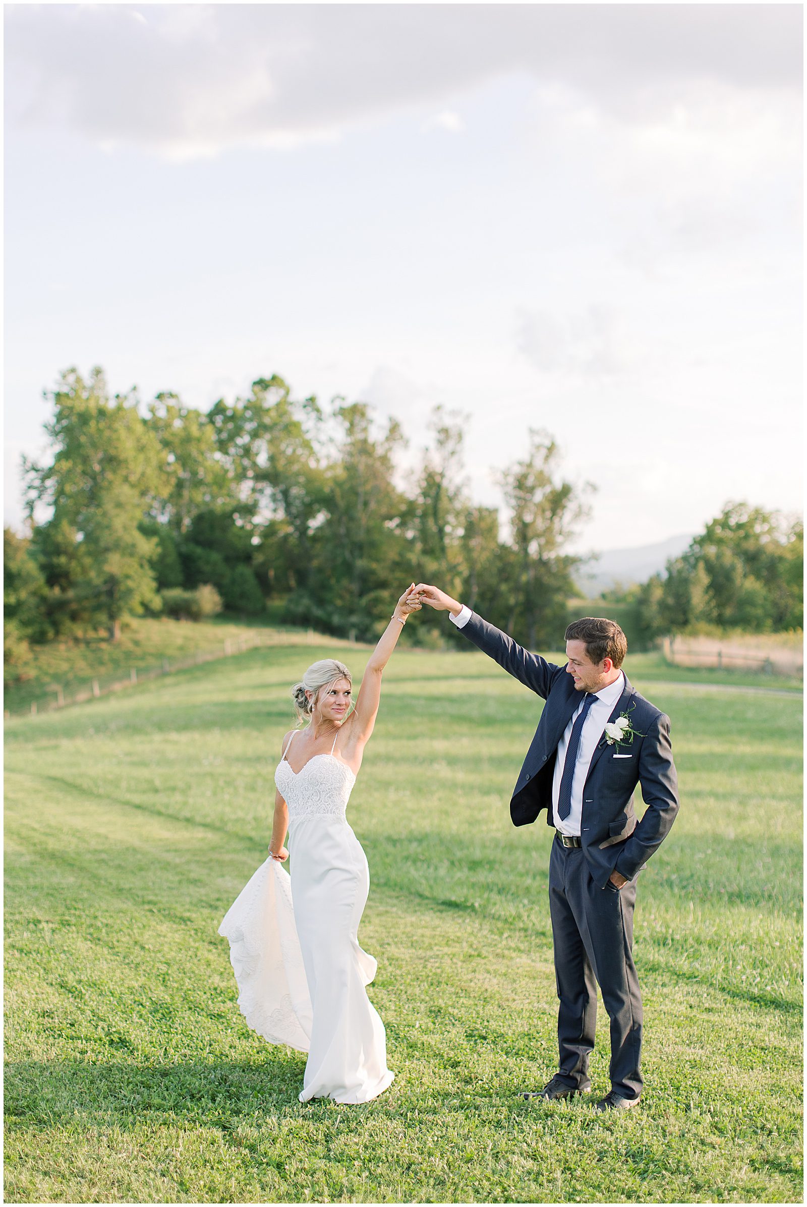 Bride and Groom Twirling In Field Photo