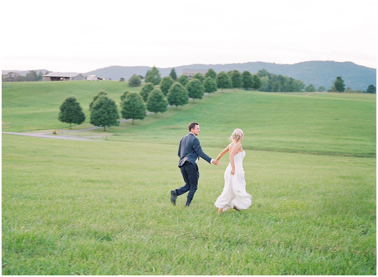 Bride and Groom Running Through Field Photo