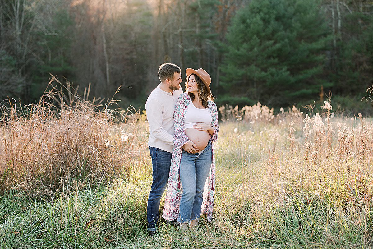 Couple in Field Holding Mamas Belly Photo