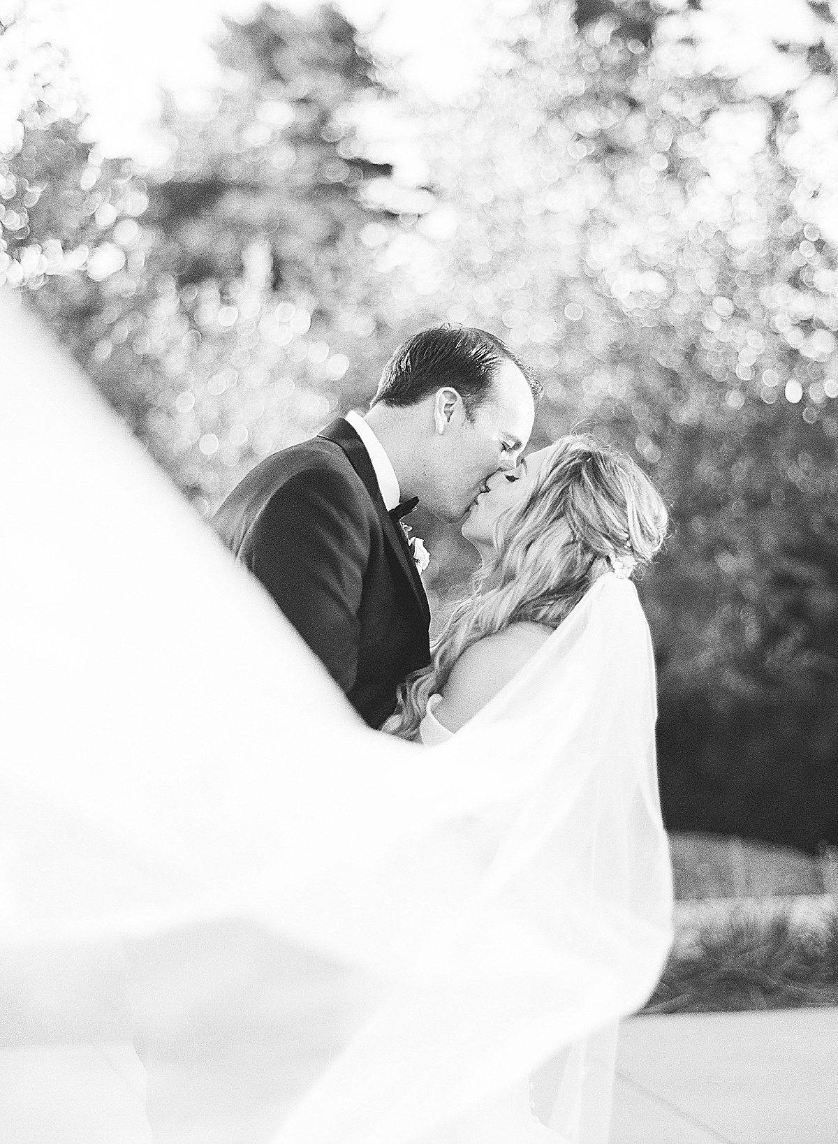 Black and White of Bride and Groom Kissing Photo
