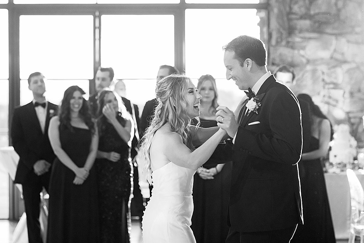 Black and White of Bride and Groom Laughing At First Dance Photo