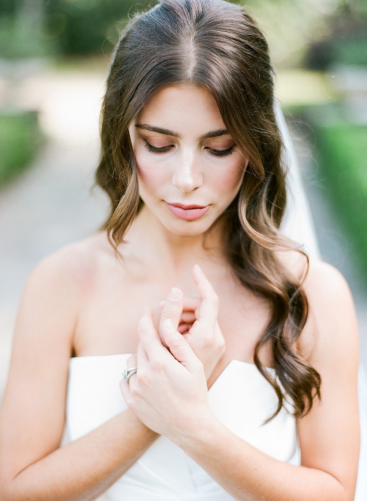 Bride Holding Hands On Chest Looking Down Photo