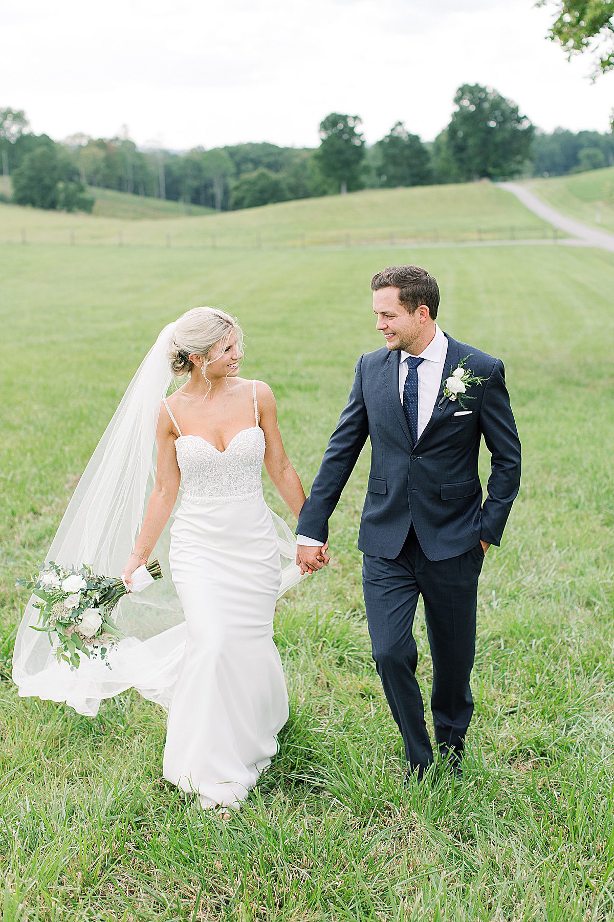 Bride walking with Groom Wearing Ti Adora by Allison Webb Wedding Gown Photo