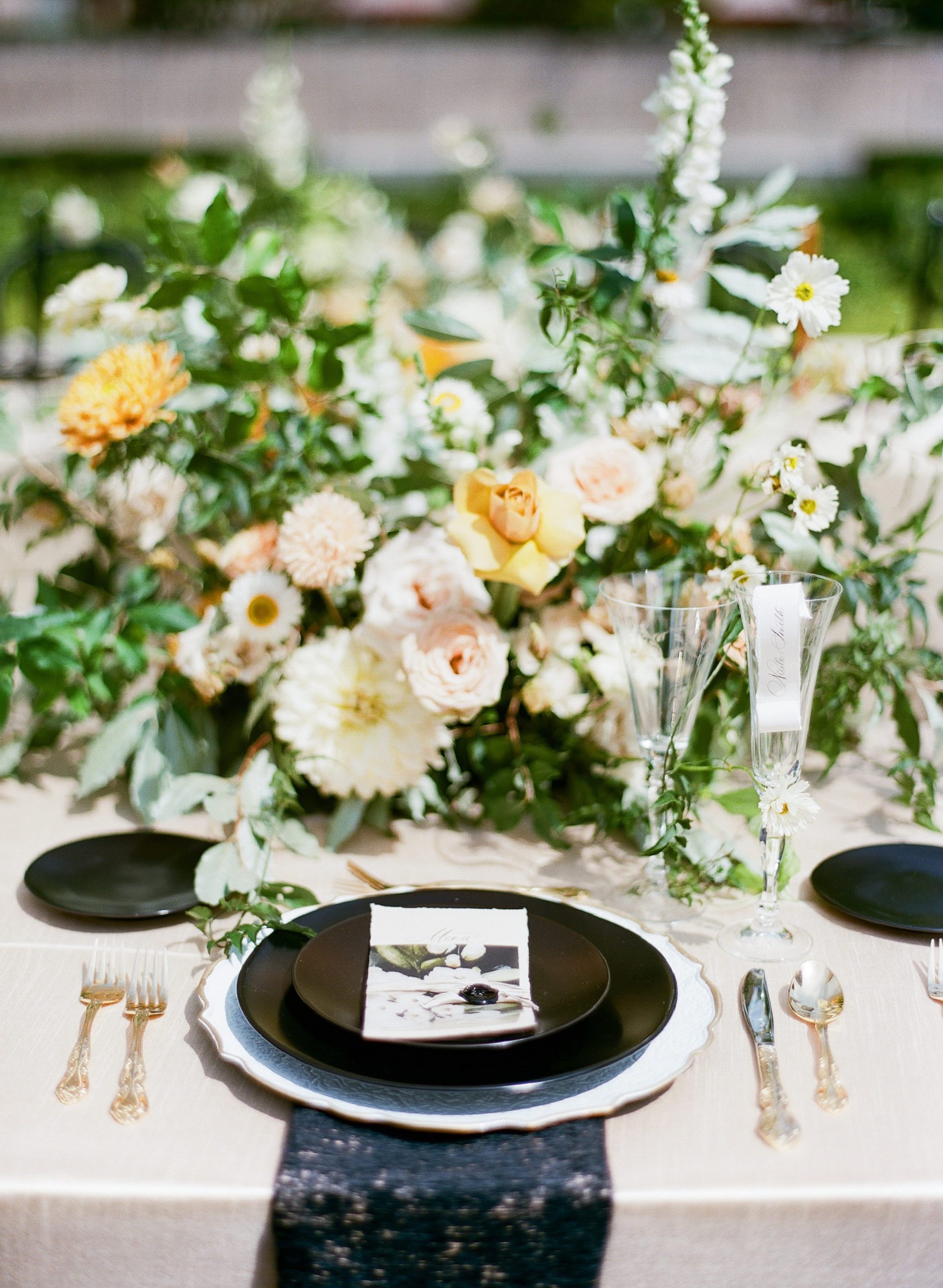 Wedding Reception Table with Black Plates and Yellow Flowers Photo