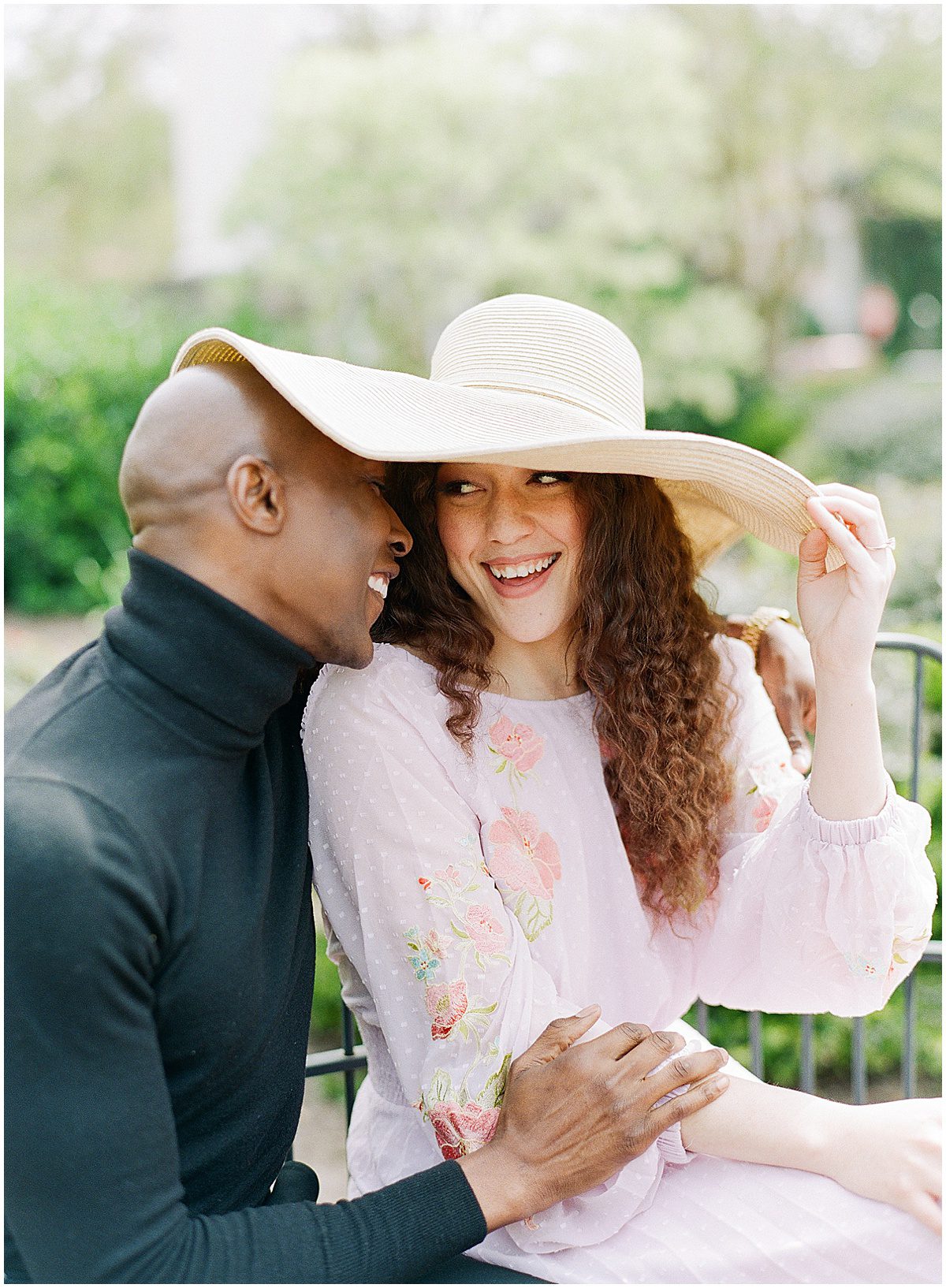 Couple Laughing Under Big Hat Photo