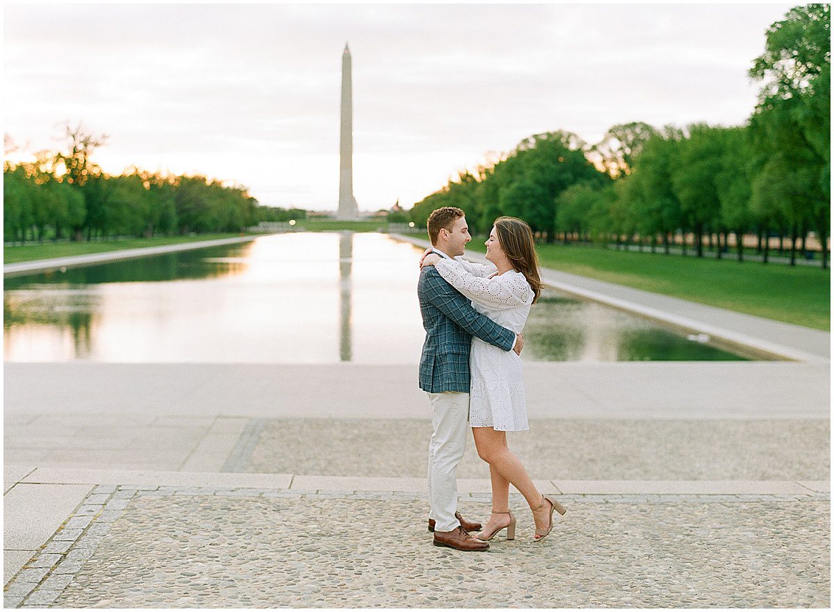 Couple Hugging with Washington Monument Behind Them Photo