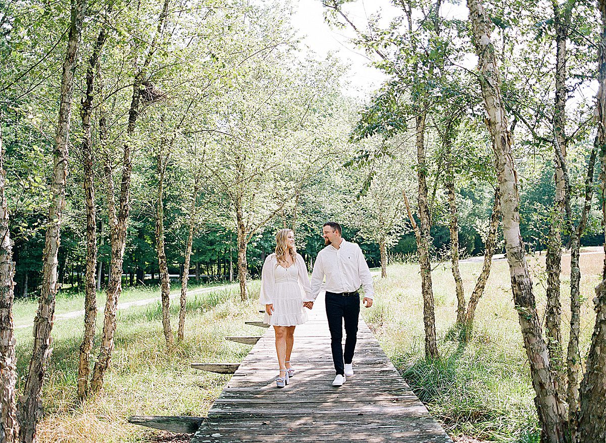 Couple Holding Hands Walking Toward Camera Engagement Session at Serenbe Photo