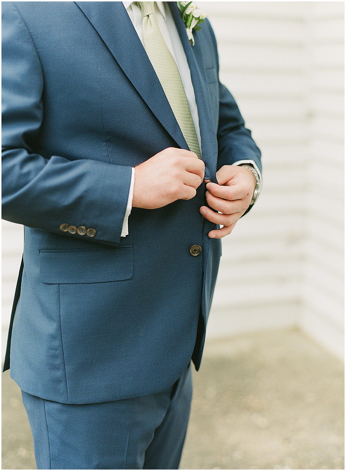 Detail of Groom Buttoning Suit Photo