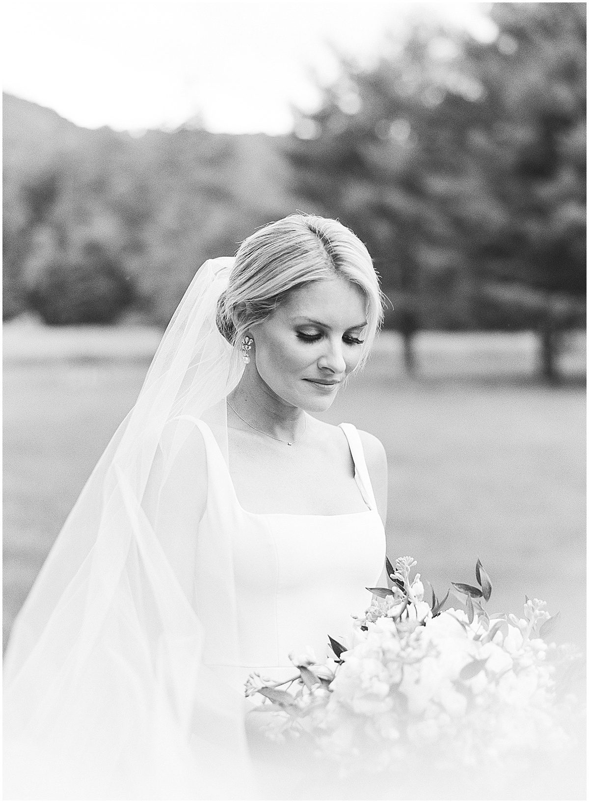 Black and White of Bride Looking at Bouquet Photo