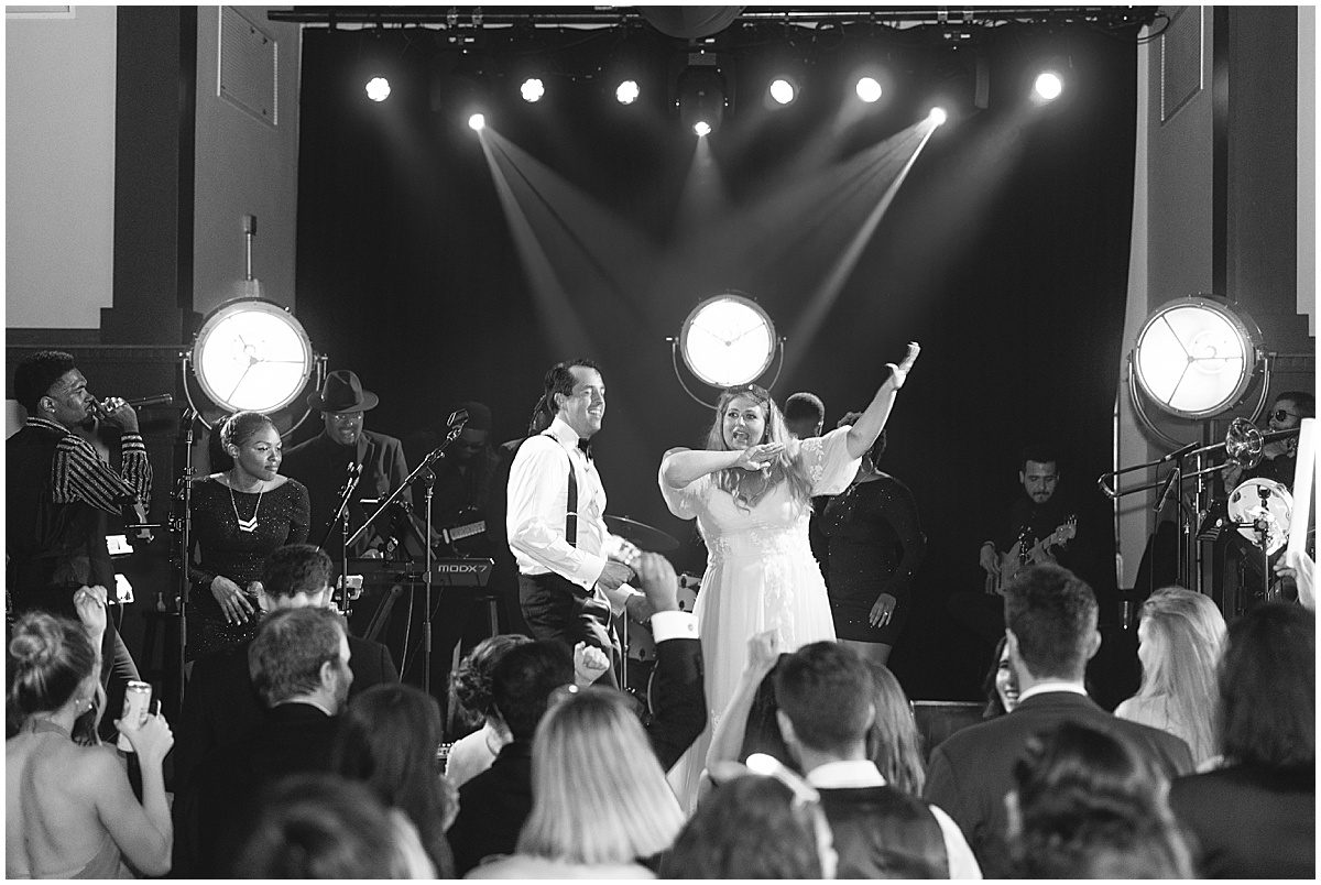 Black and White of Bride and Groom on Stage at Wedding Reception Photo