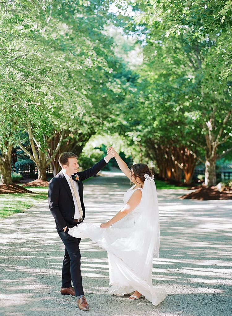 Wedding at Hawkesdene Estate Bride and Groom Twirling in Driveway Photo