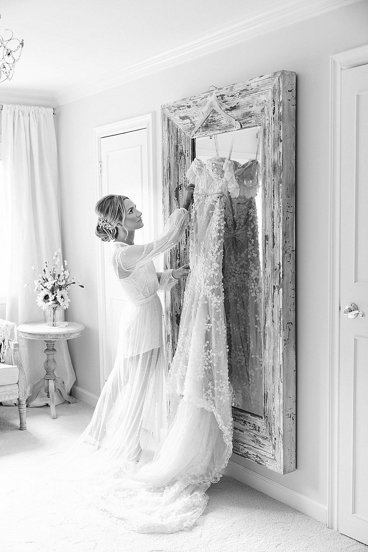 Black and White of Bride Looking at Wedding Dress Photo