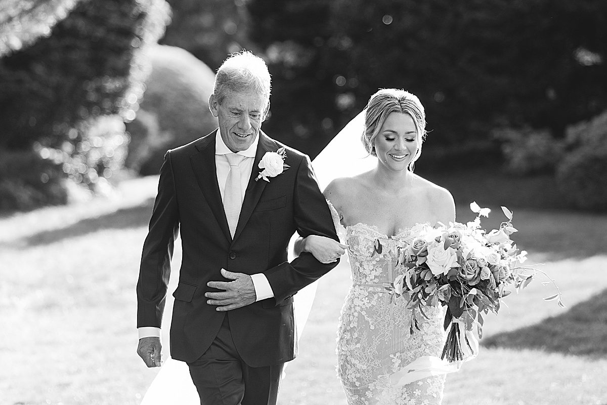 Black and White of Bride Walking Down Aisle with Father Photo
